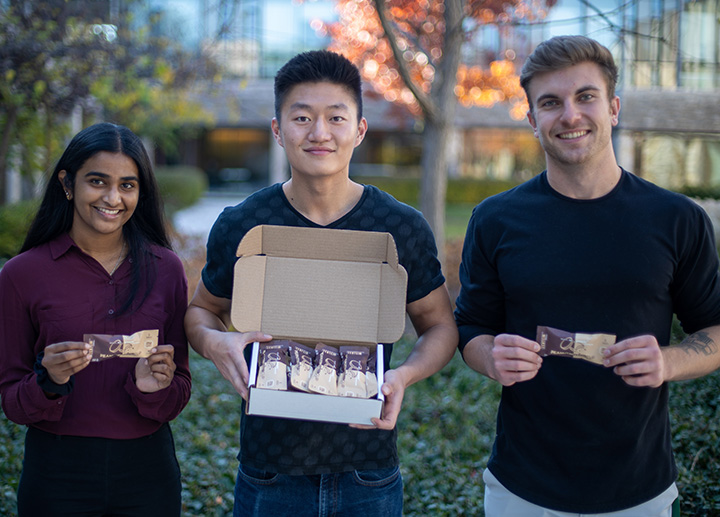 Group of 3 students holding up chocolate bars